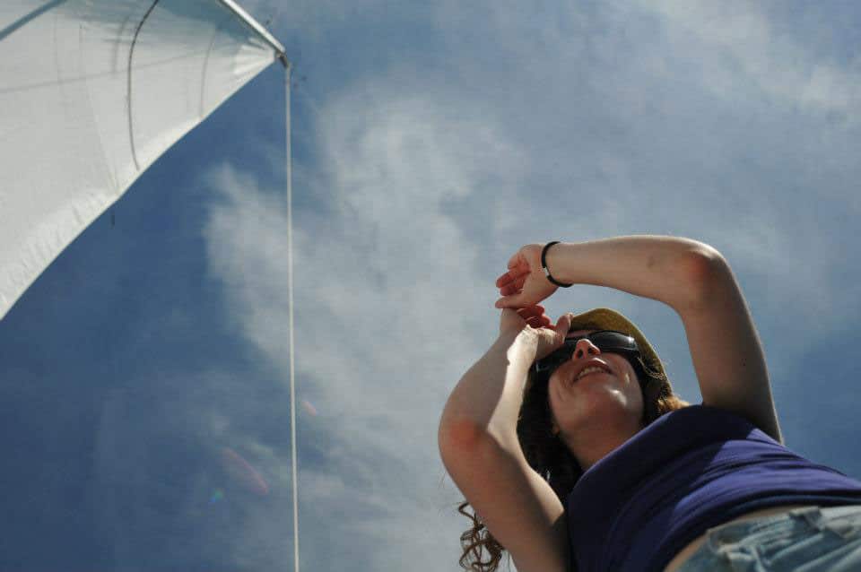 Sur un voilier, une femme regarde à l'horizon